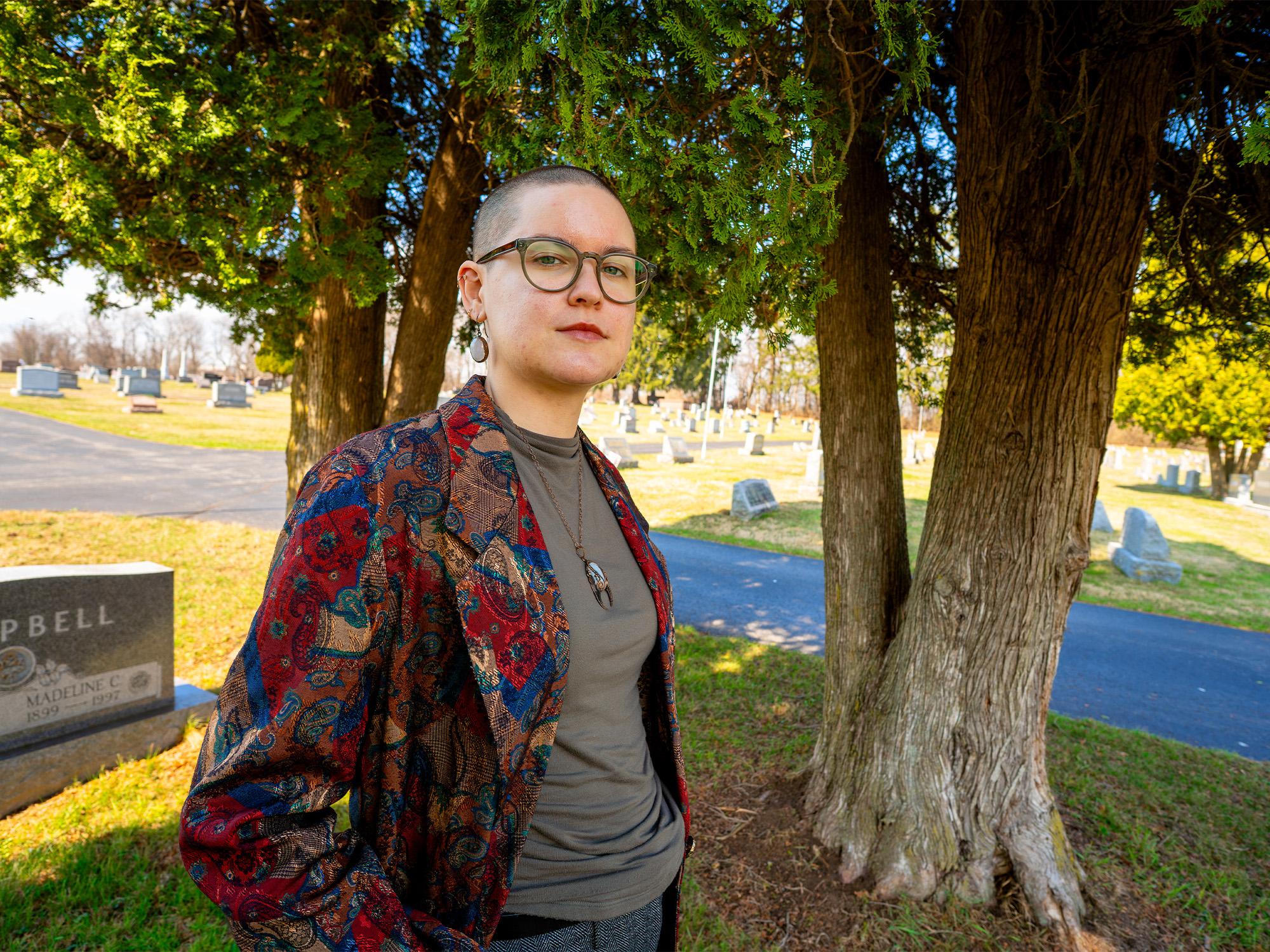 woman in cemetary in front of tree