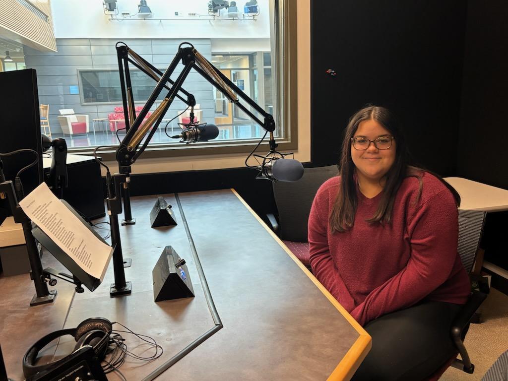 Student sitting at the microphone in a radio studio