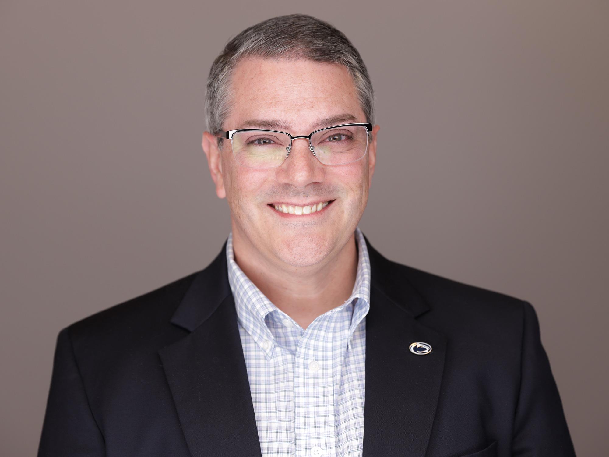 A man wearing glasses and a suit.