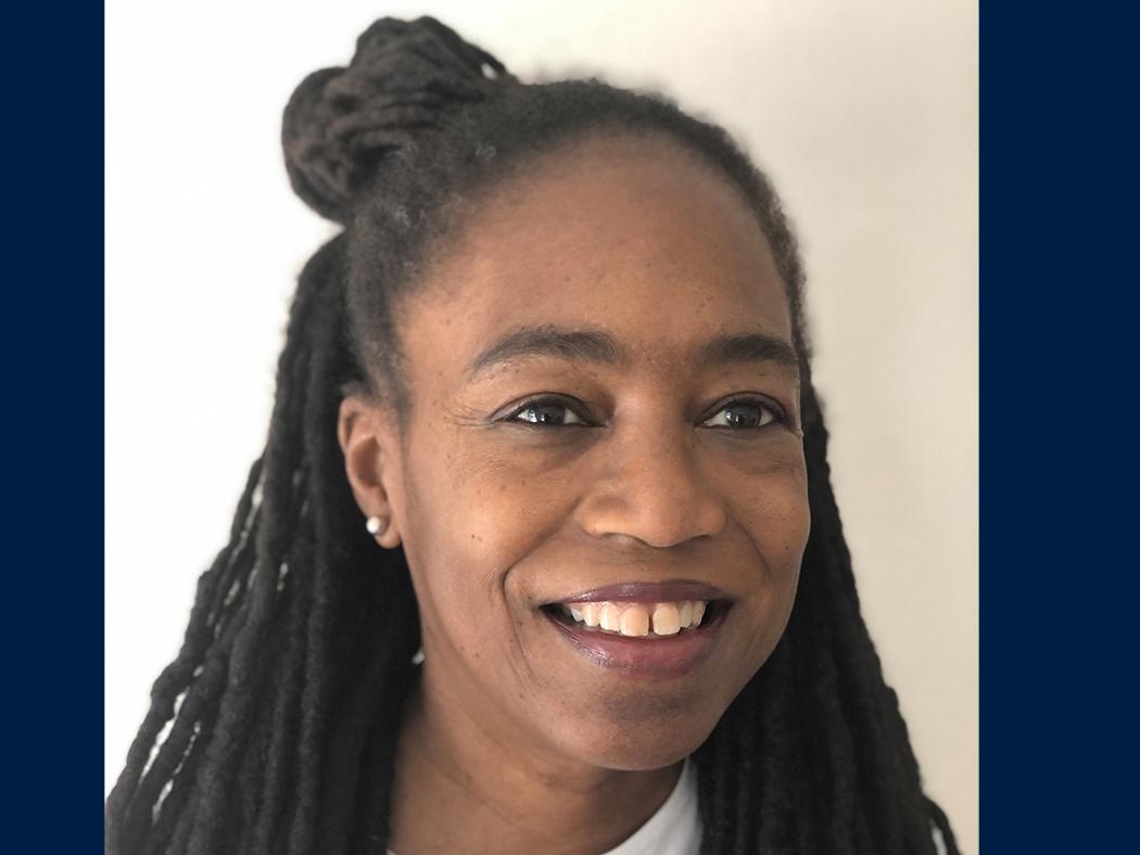 The headshot of a Black woman against a white background. 