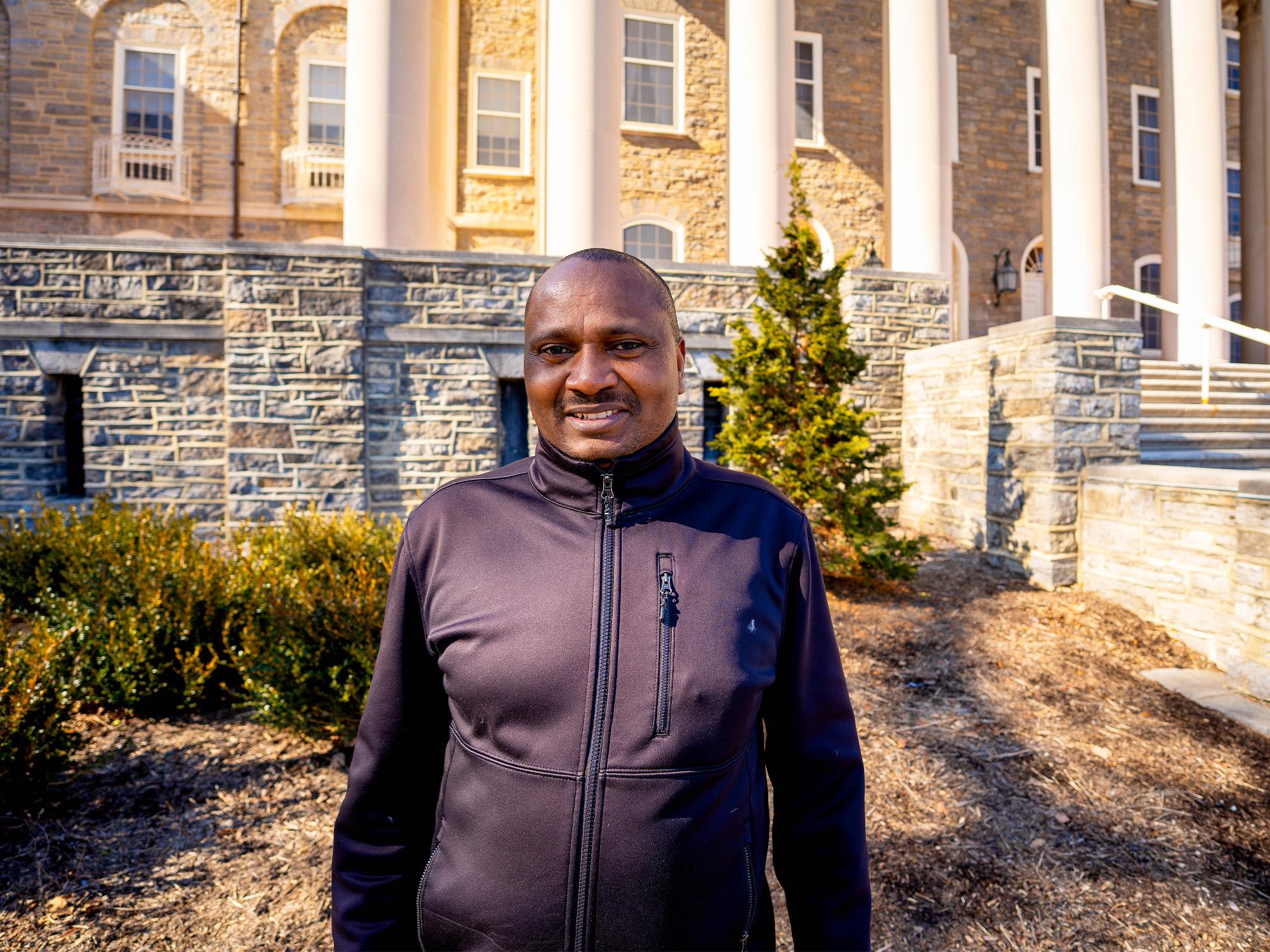 person smiling in front of building with pillars
