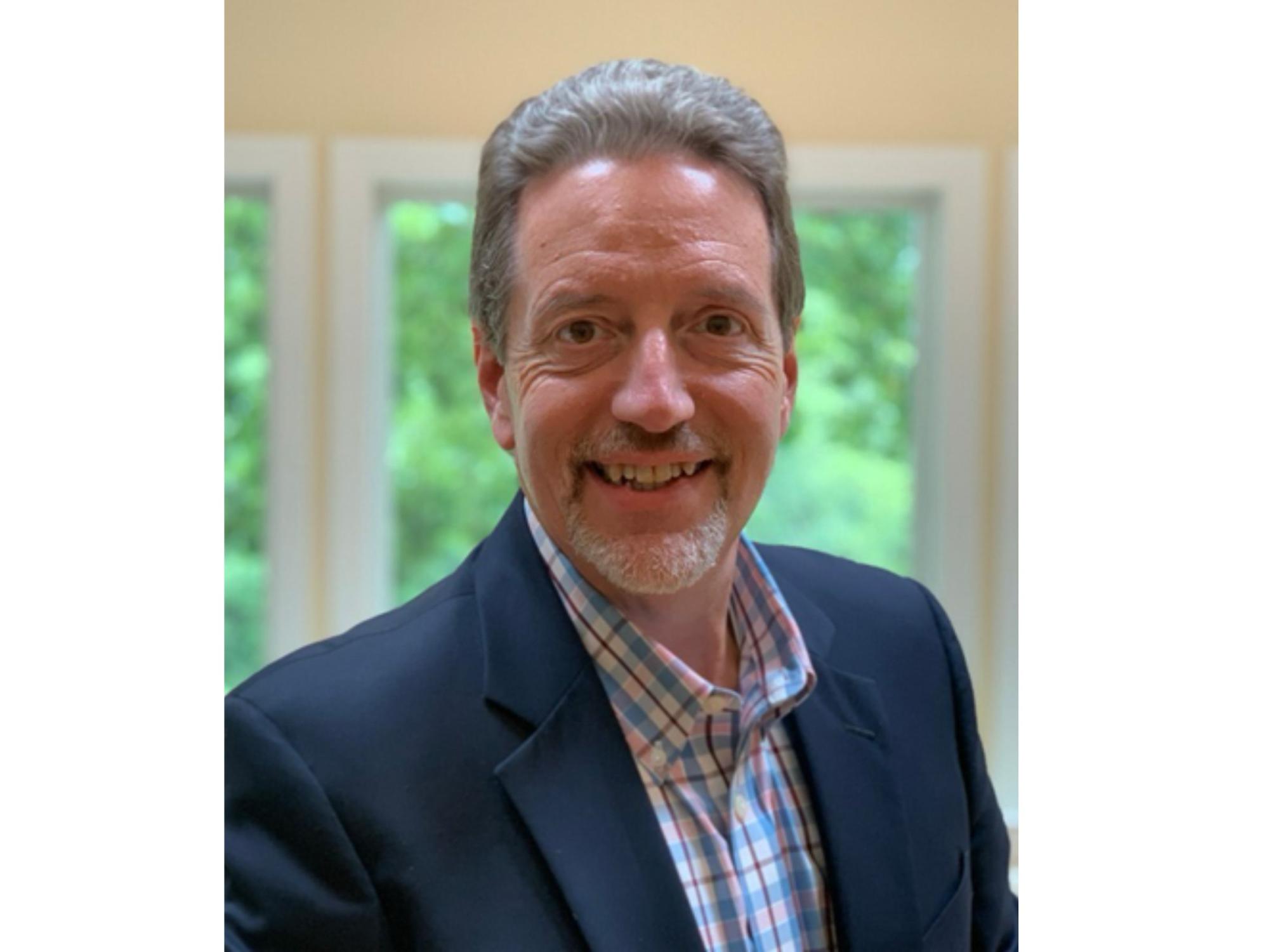 smiling businessperson with gray hair and mustache