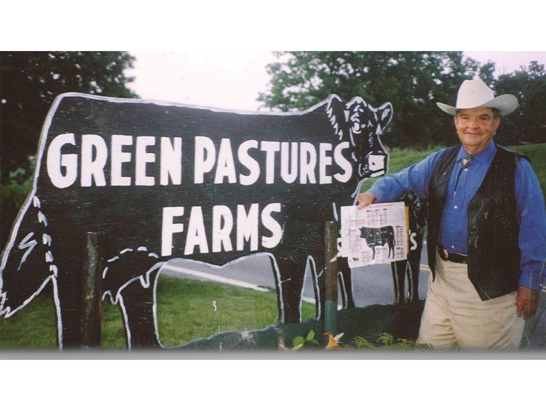 photo of Harry Stambaugh by his Green Pastures Farms sign