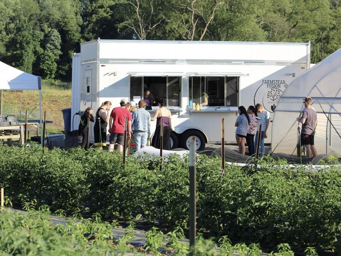 Visitors wait in line to enjoy dishes from a food truck on the Student Farm.