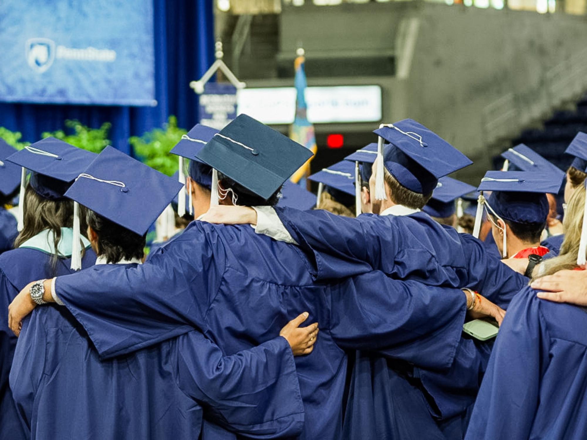 a group of college graduates in blue caps and gowns 