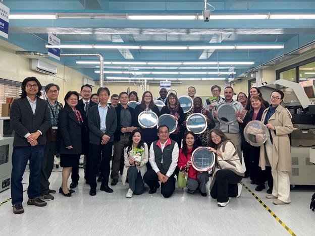 A large group of people posing for a picture inside a lab