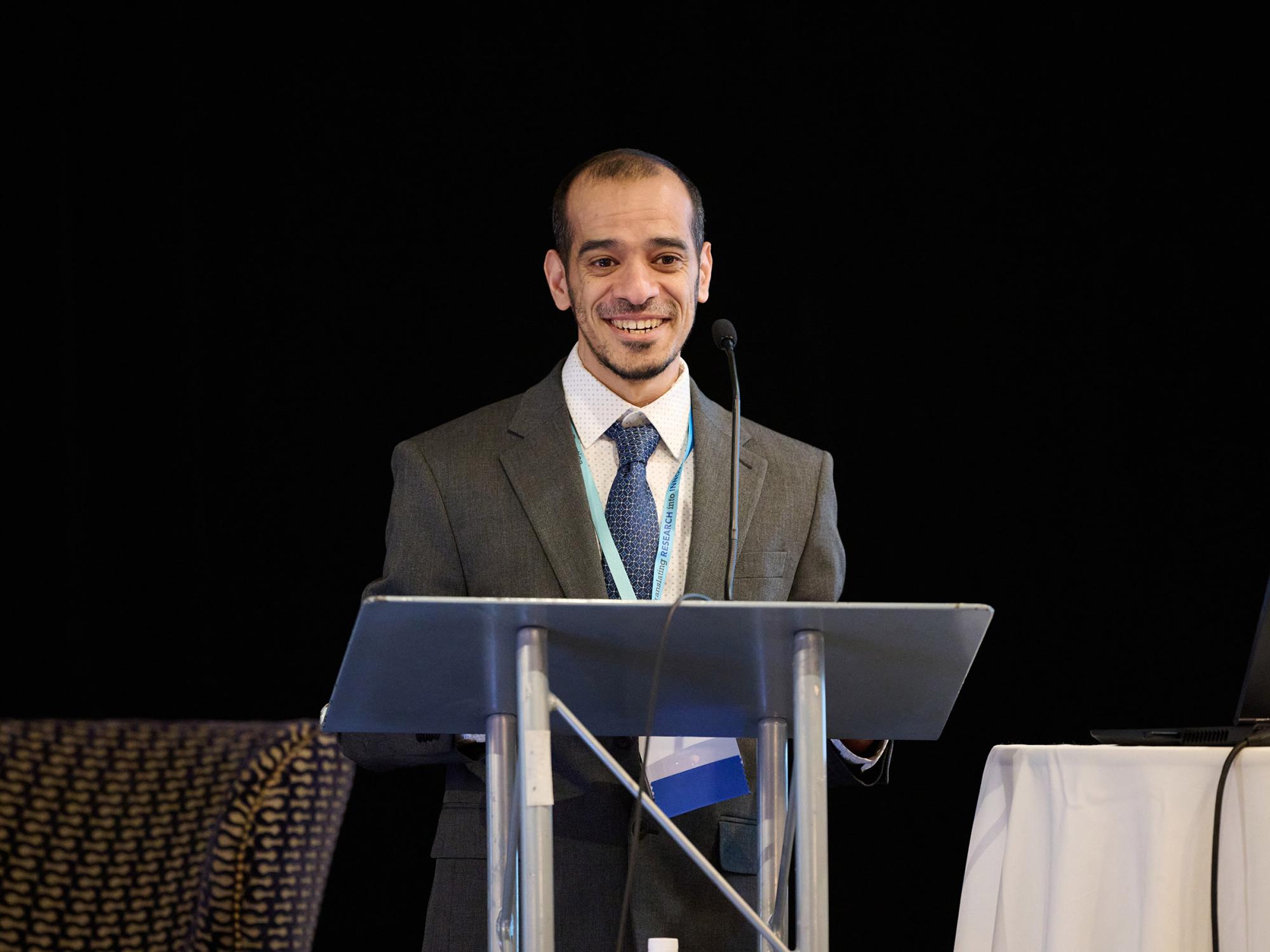 professor khalid almasloukh standing at podium speaking at nursing symposium