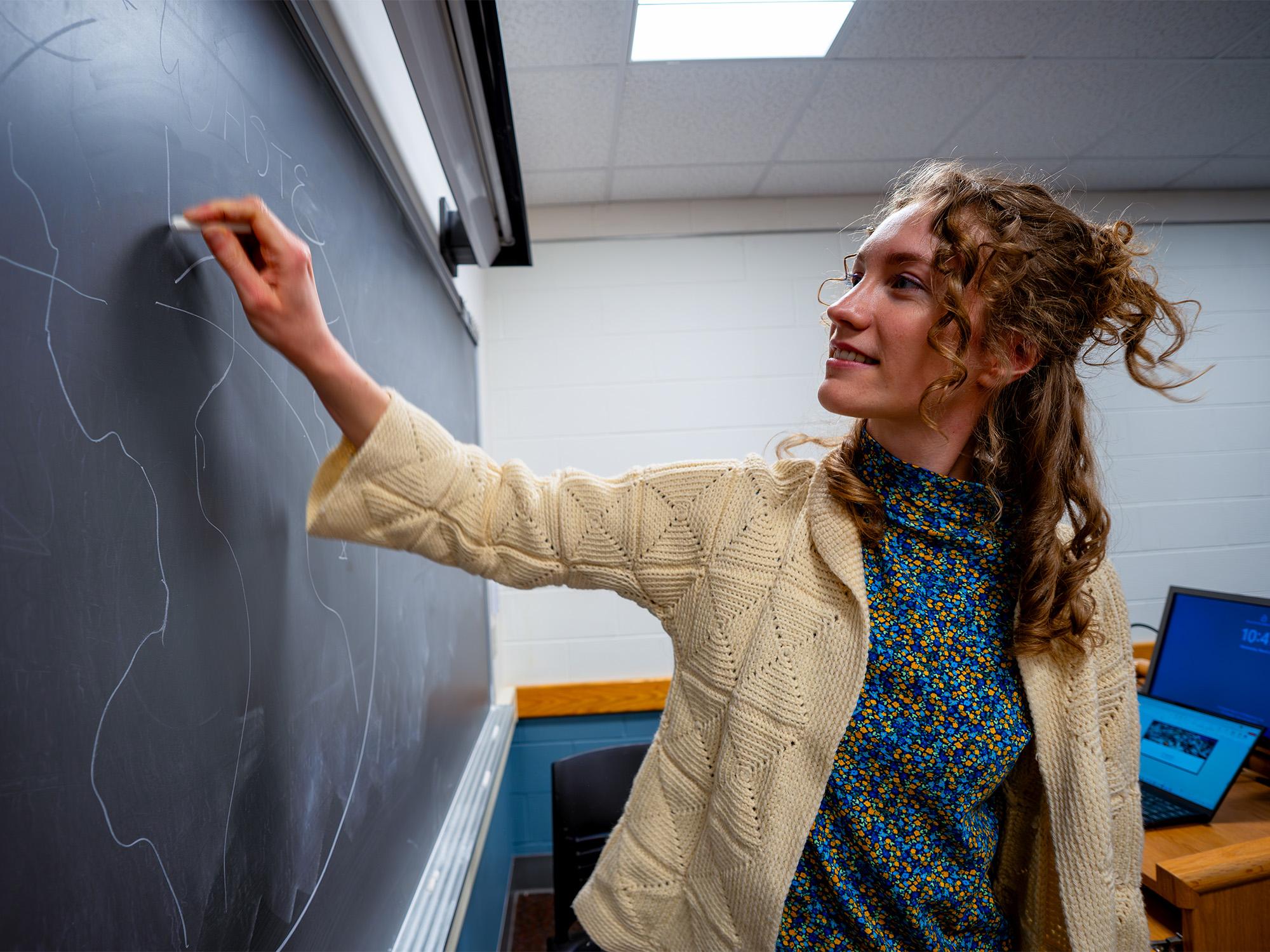 woman writing on chalkboard