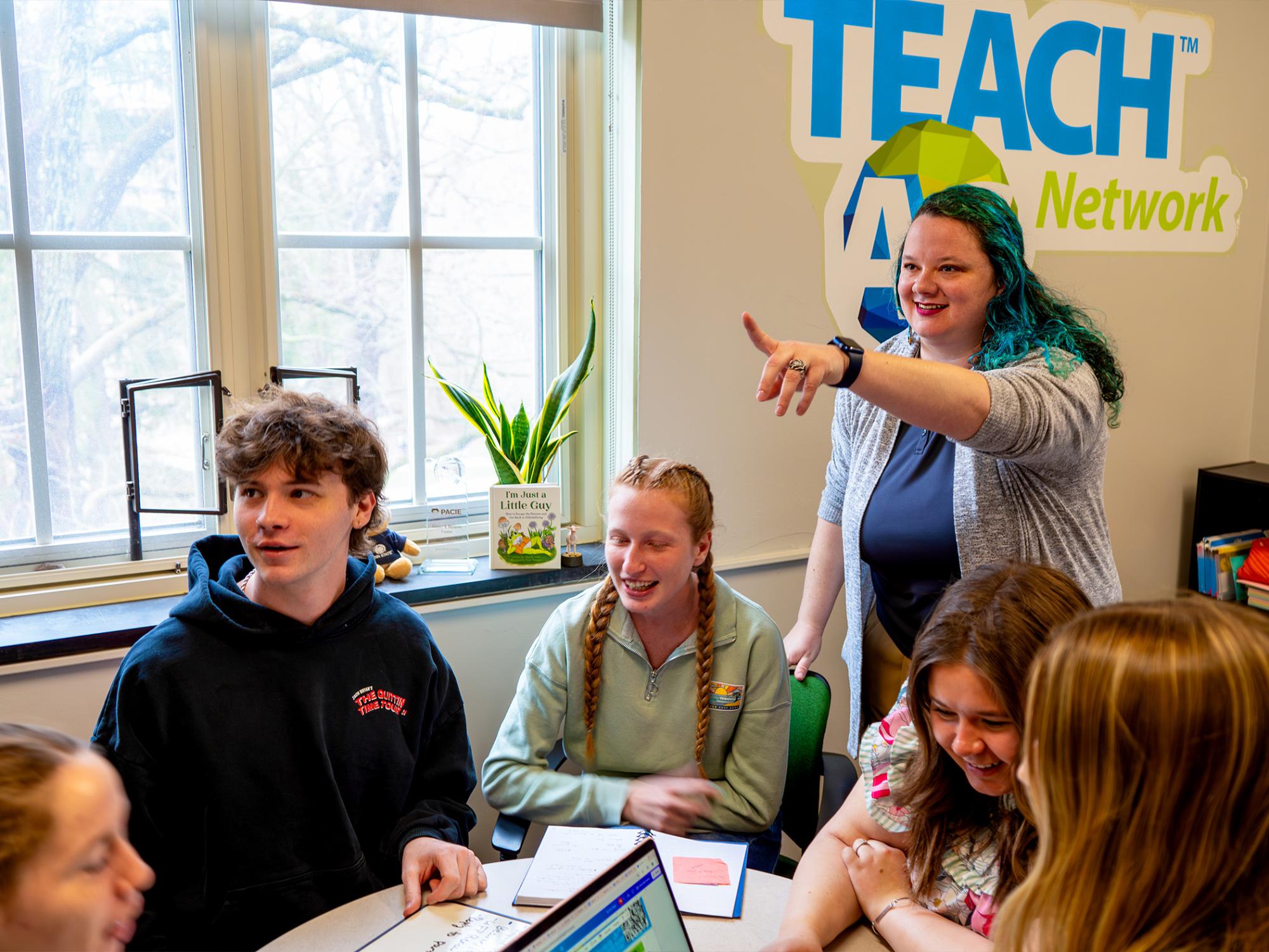 woman teaching class and pointing while students look