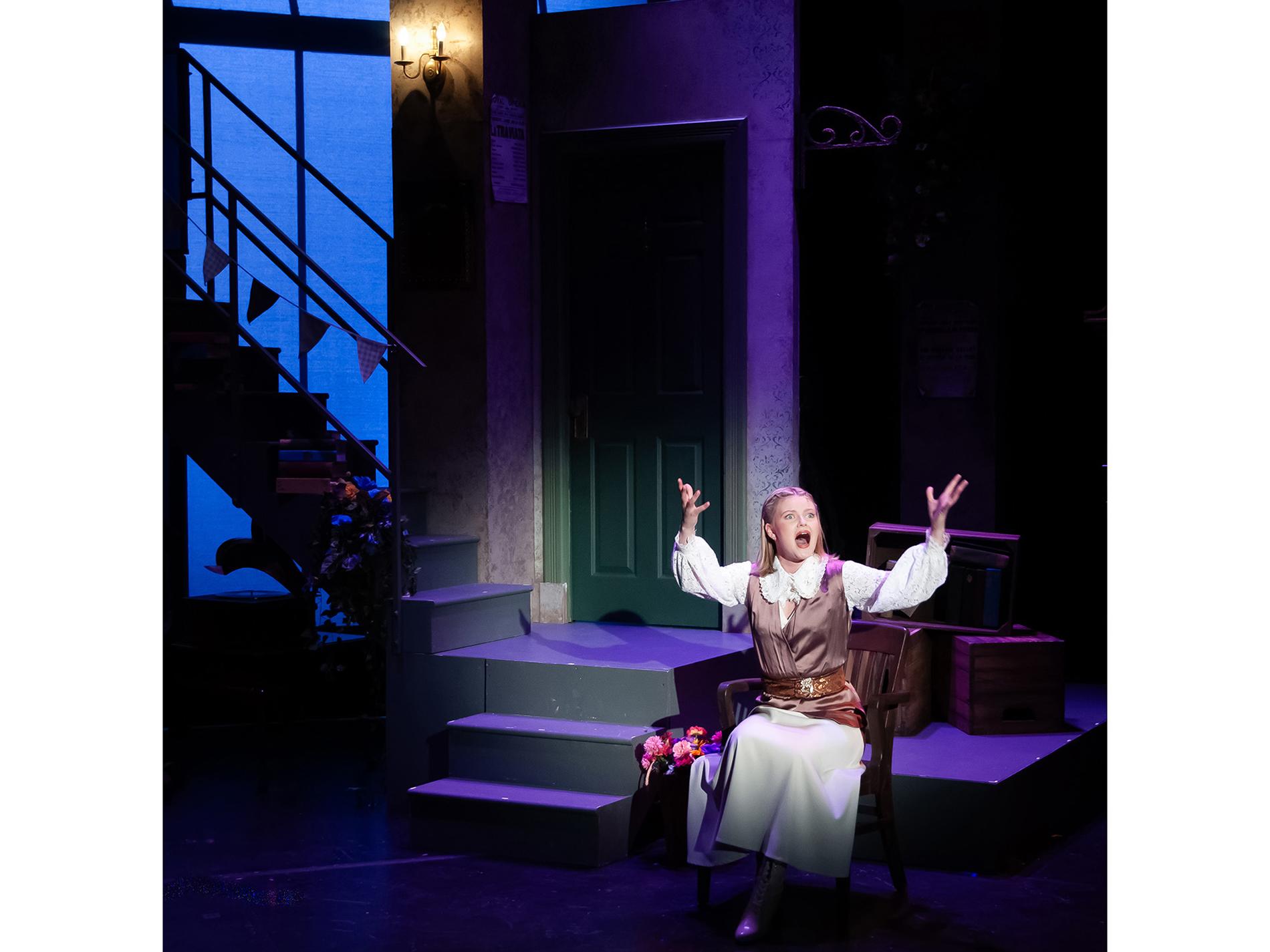 An actor sings on a theatrical stage