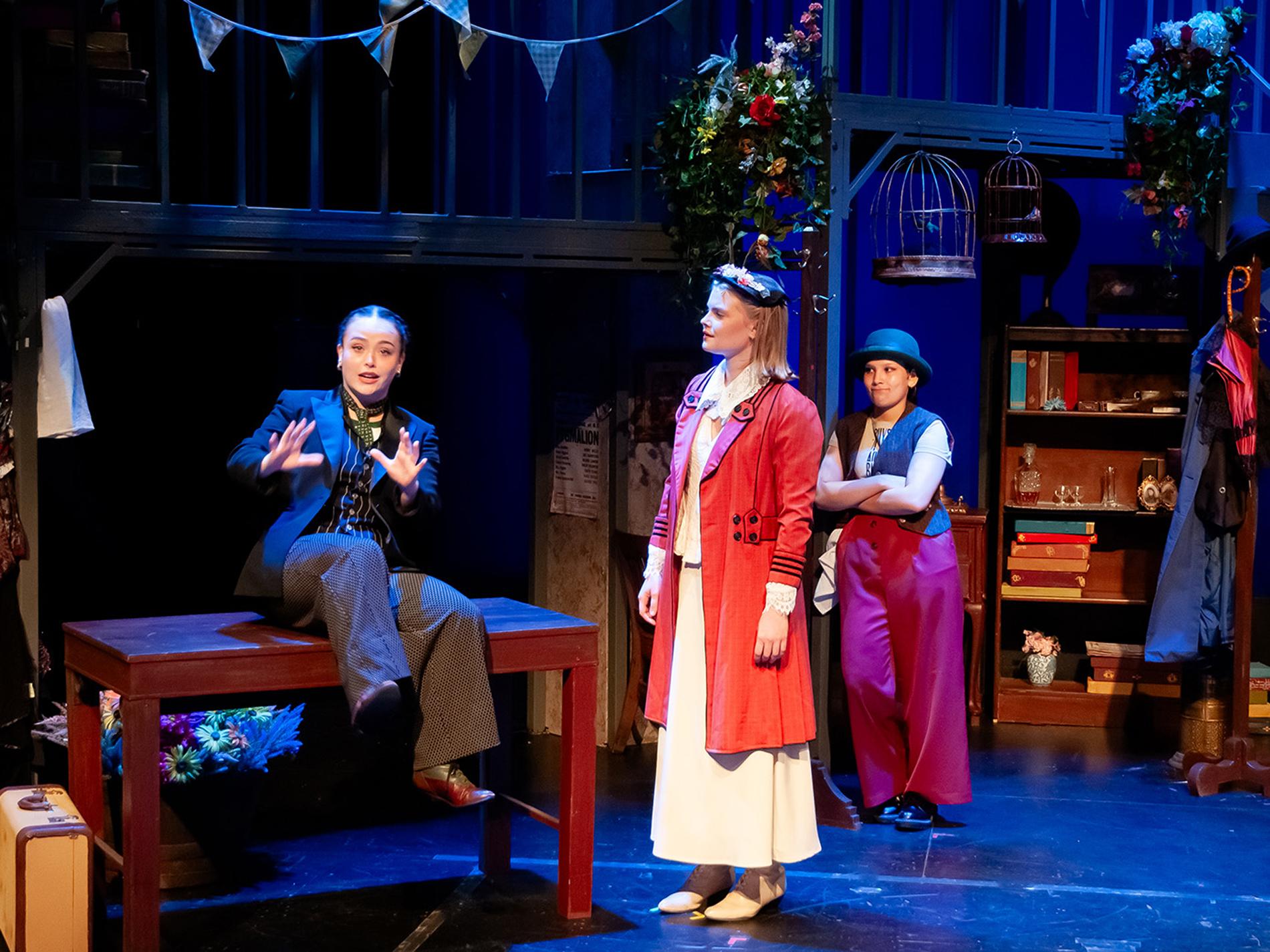 Three actors perform on a stage