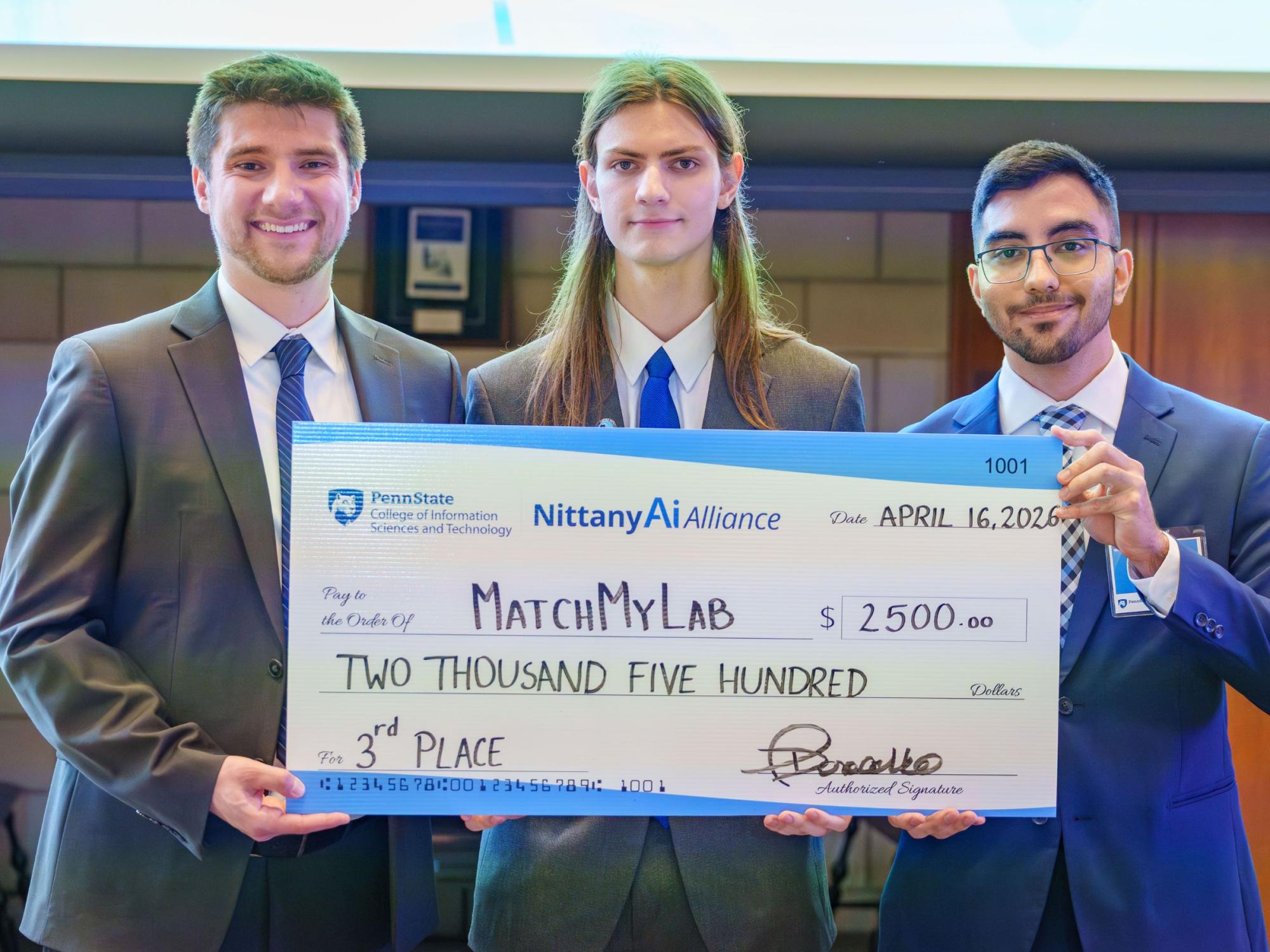three young adults wearing suits display large check