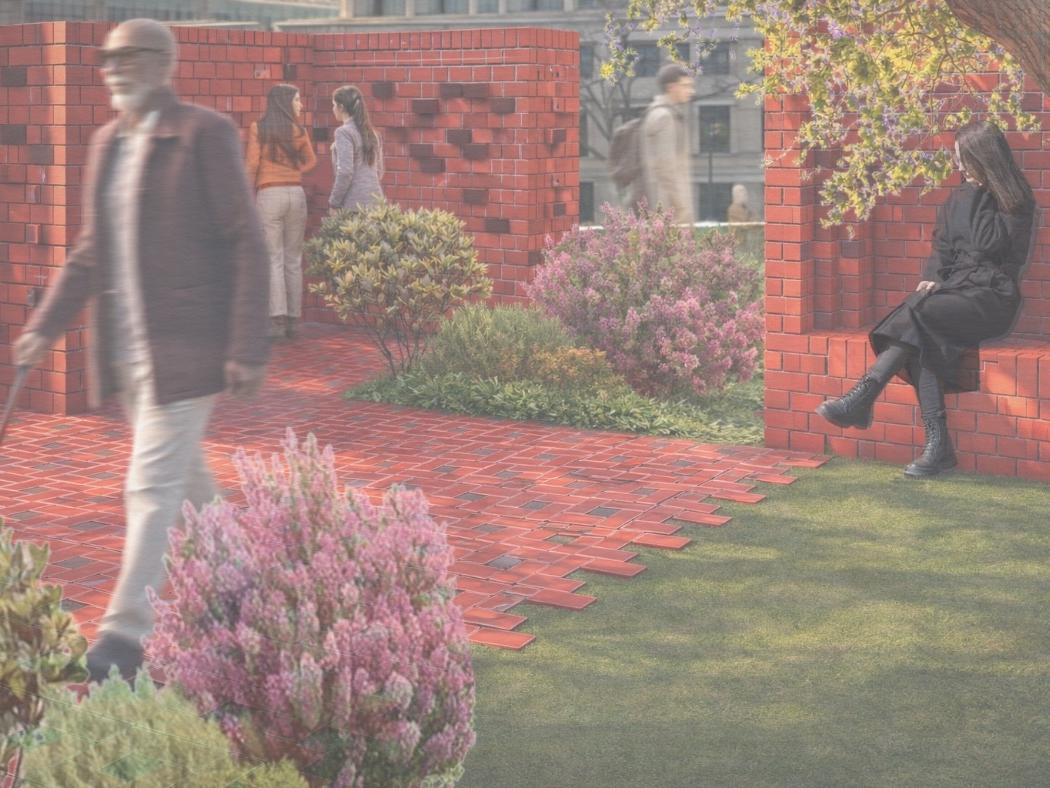 People move through a landscaped public installation featuring red brick walls and pathways, flowering shrubs, and a grassy area, with one person seated on a built‑in brick bench beneath a tree.