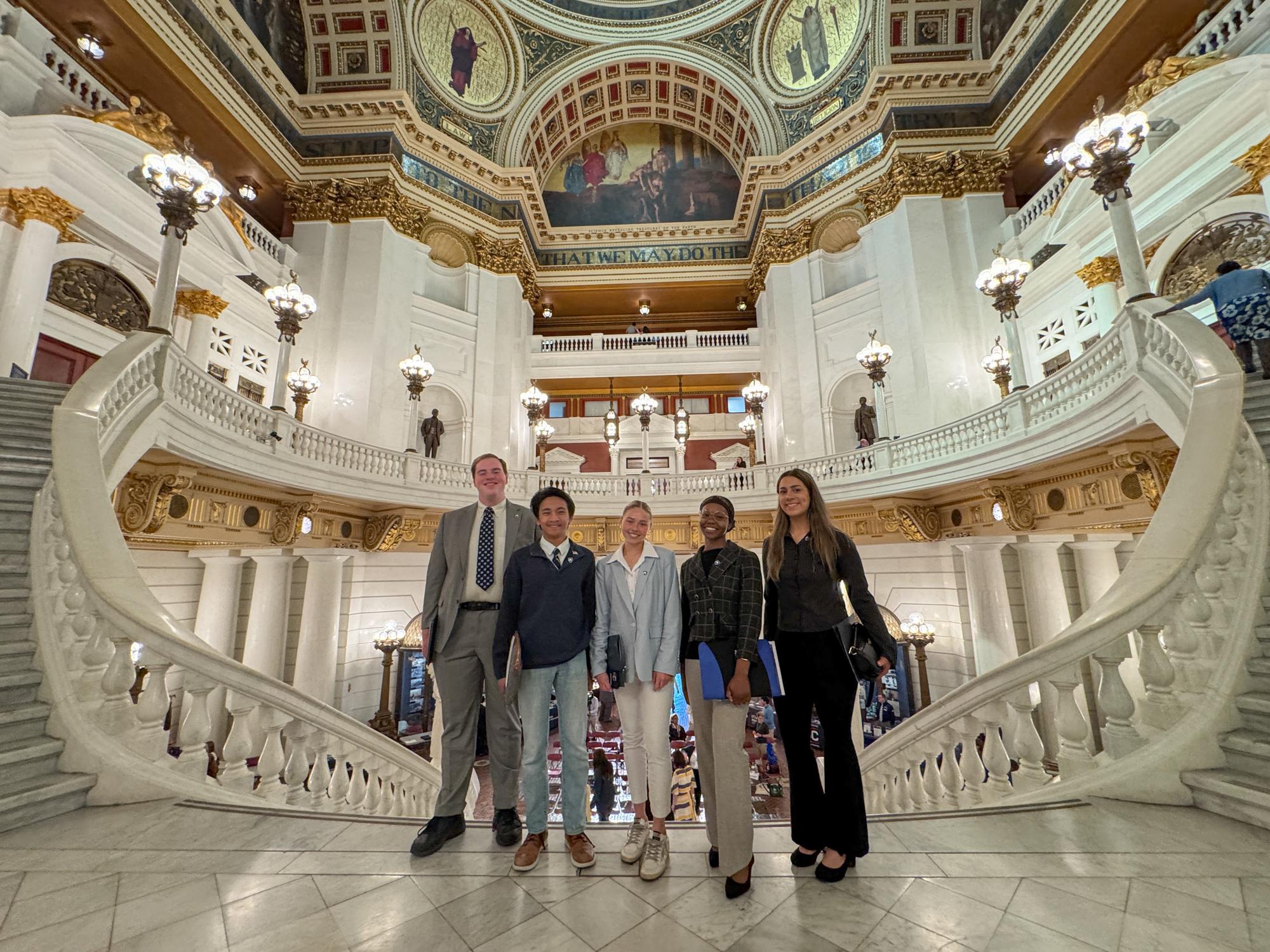 Five students stand in the Pennsylvania Capitol rotunda.