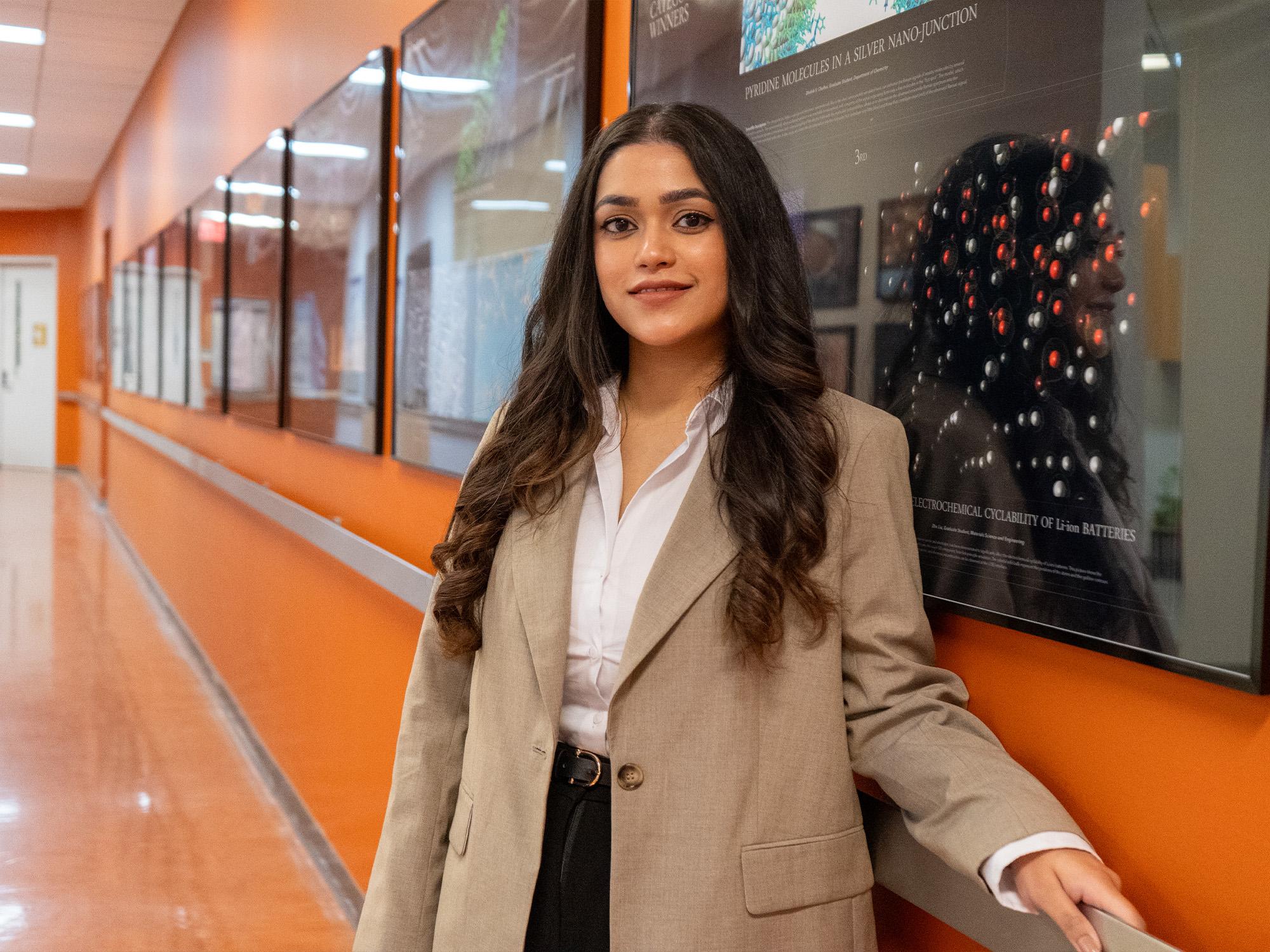 woman stands in front of data visualization poster