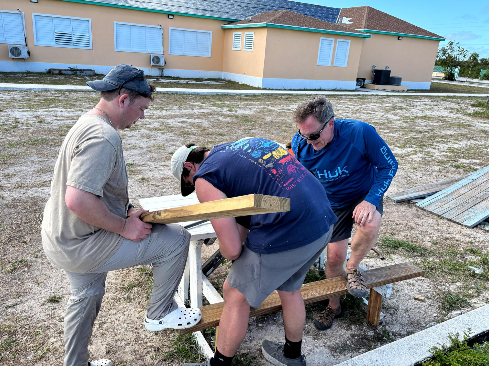 Christian Lundy, left, helps repair a bench at a school in San Salvador with help from Lee Kump