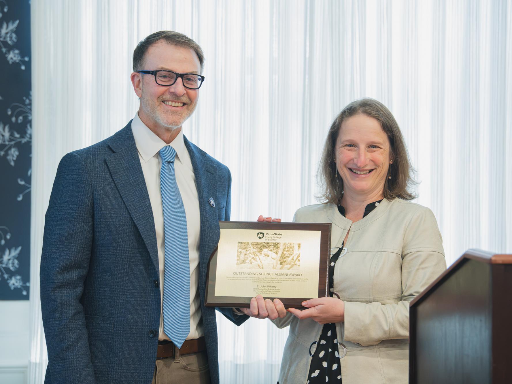 E. John Wherry accepting the Outstanding Science Alumni Award from the Penn State Eberly College of Science Dean Tracy Langkilde.