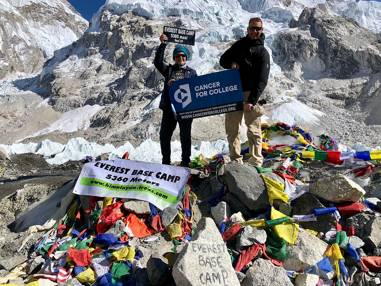 Two people stand on an icy mountain.