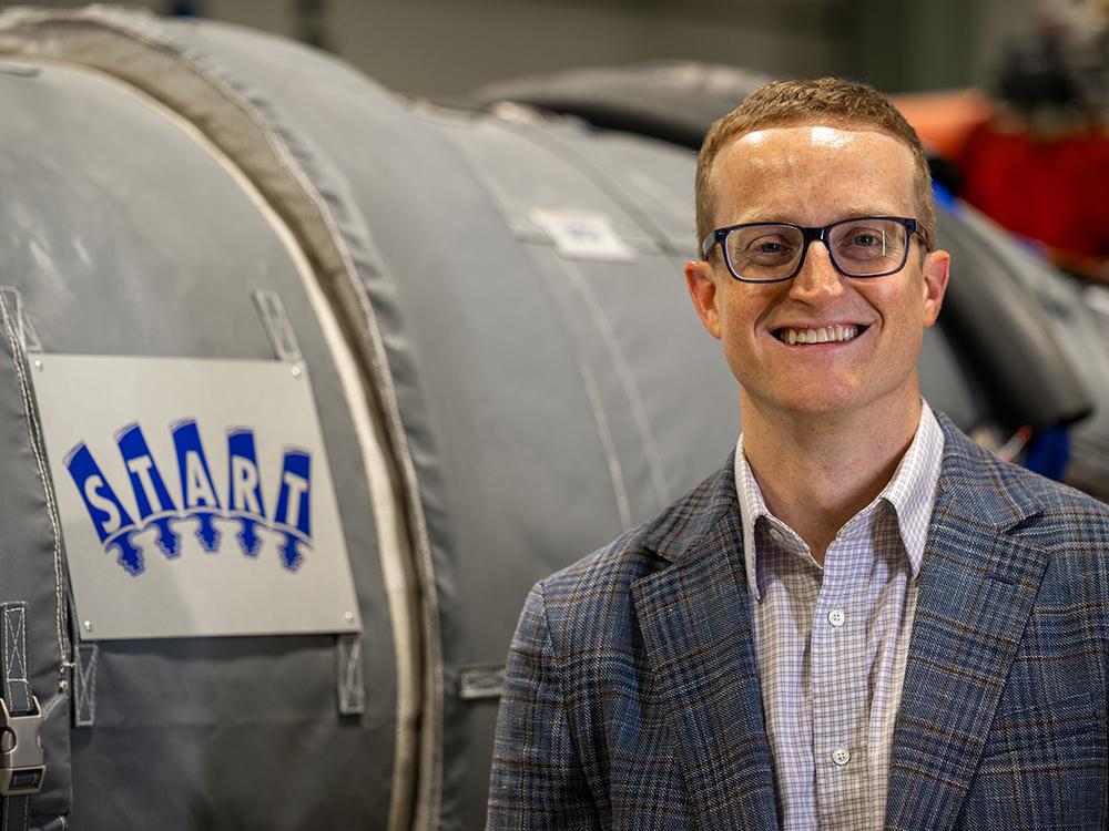A photo of Reid Berdanier smiling in his laboratory. 