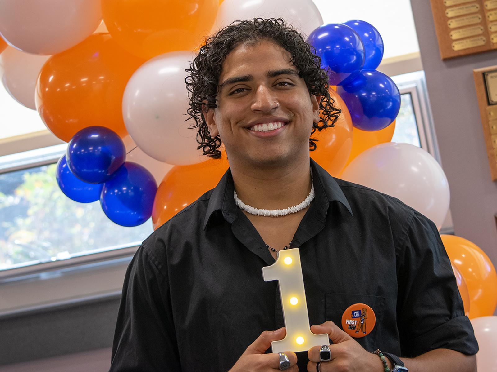 Juan Serrano holds a lighted No. 1 figure