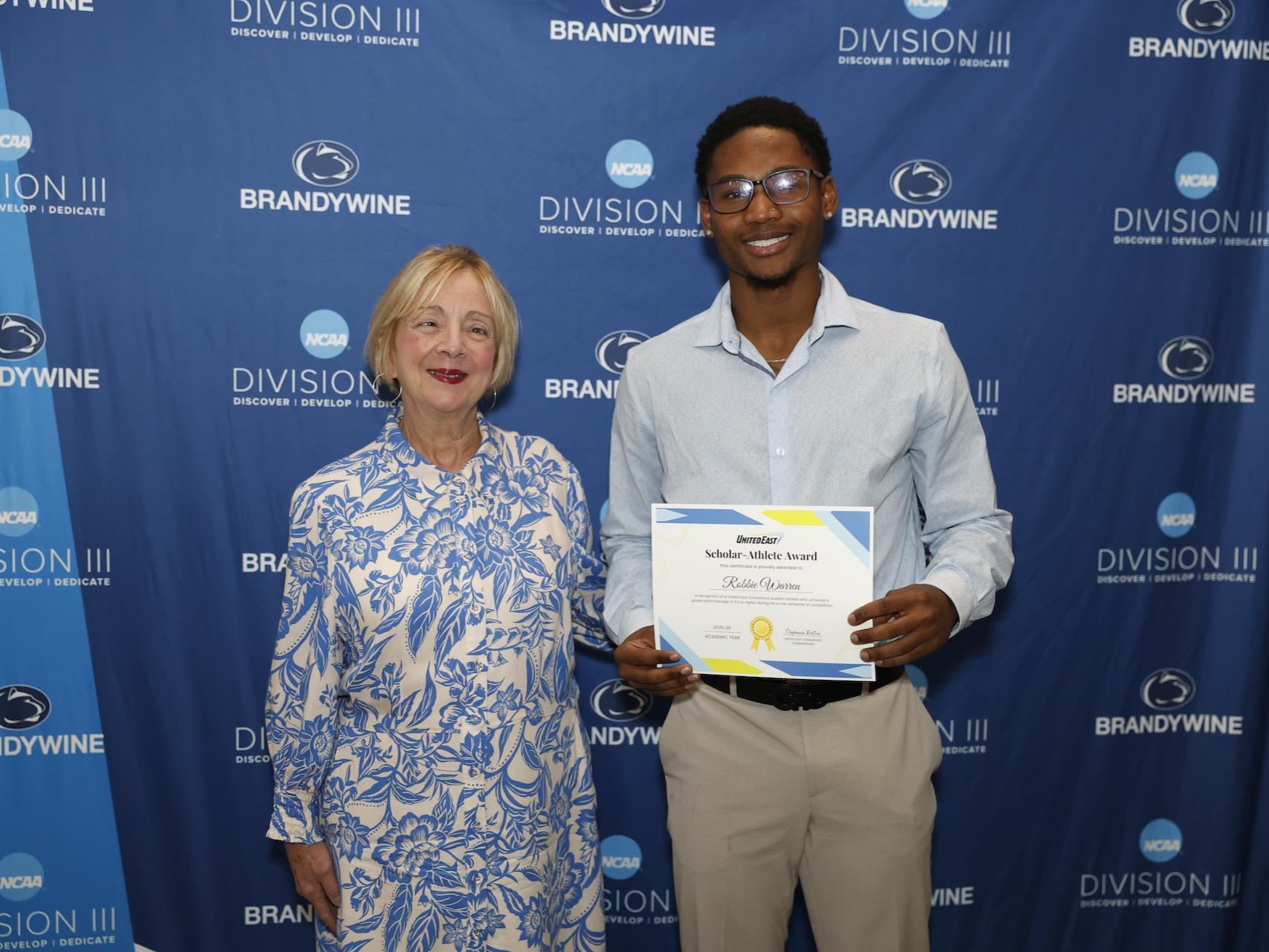 student holding certificate next to chancellor