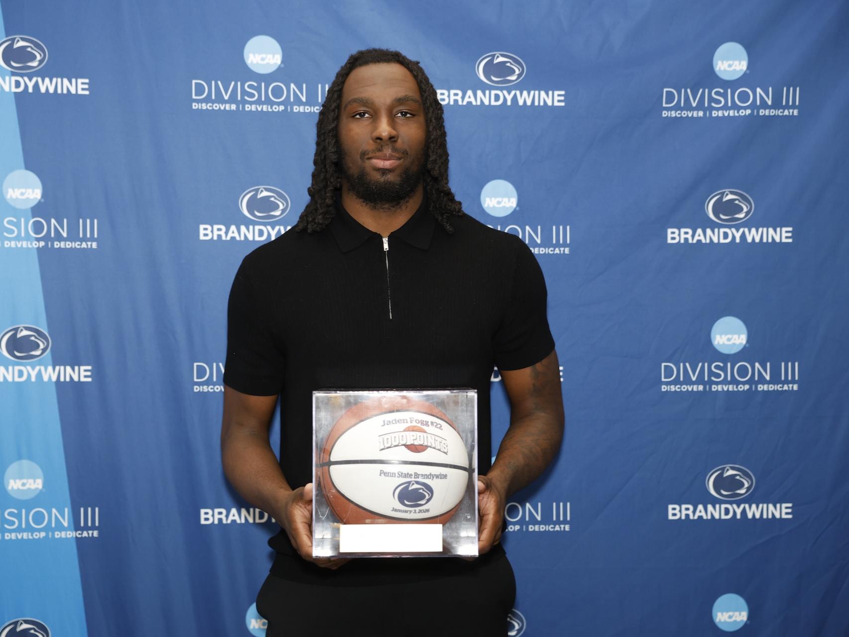 student holding a basketball in a case