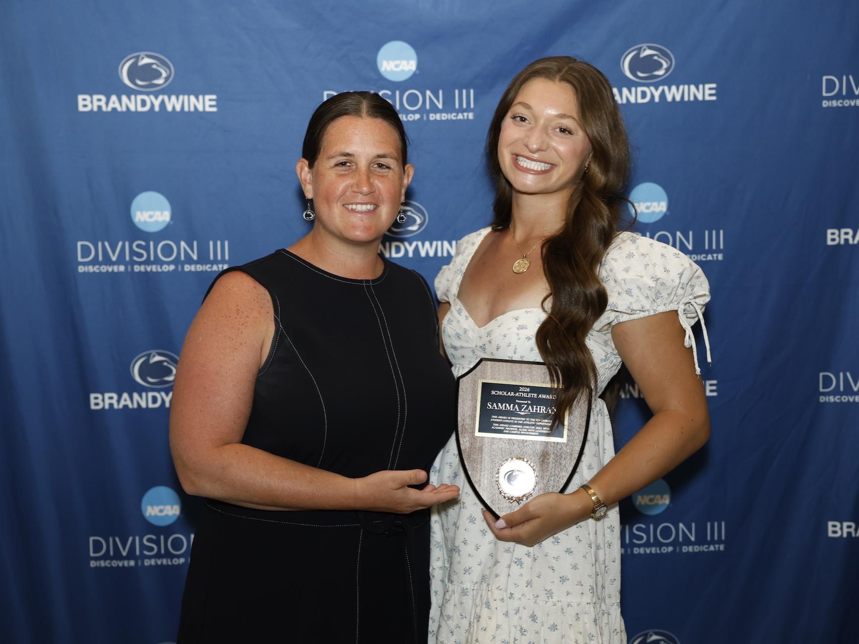 student holding plaque with director of athletics