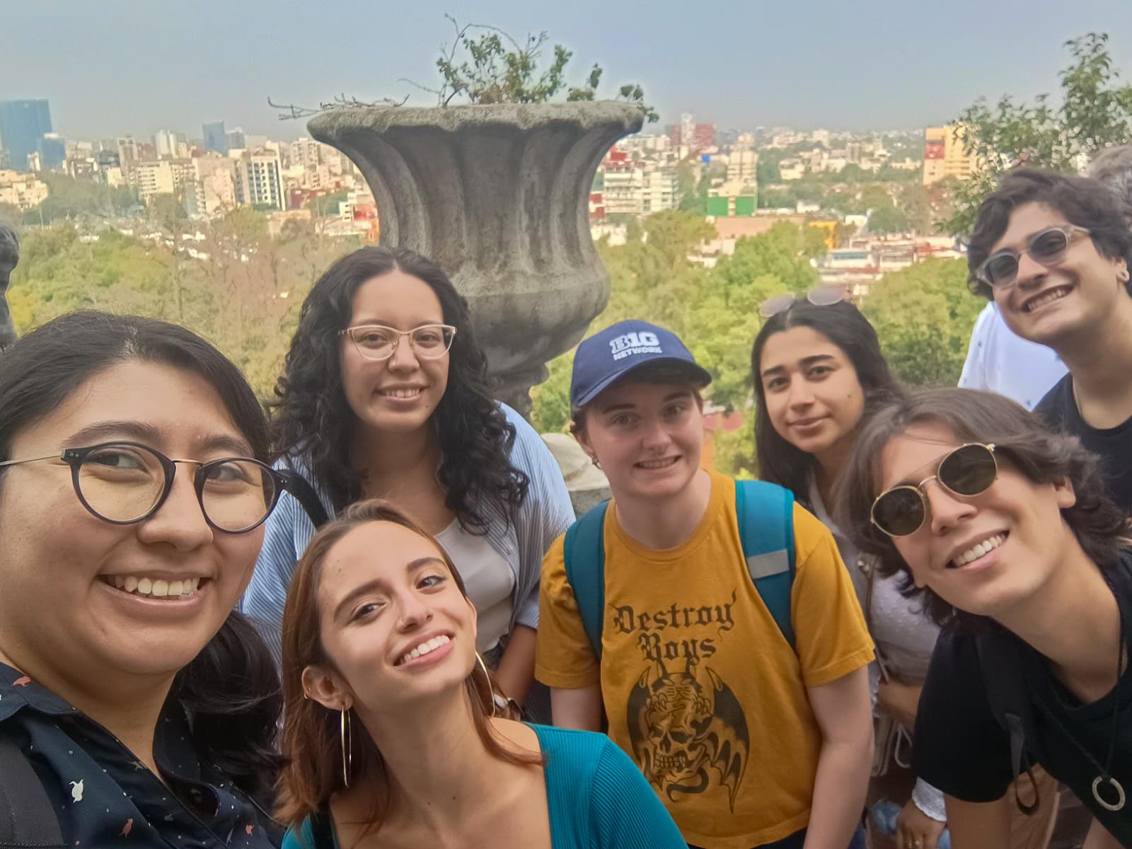 Rand Alkhunaizi and other students gather outdoors with Mexico City in the background. 