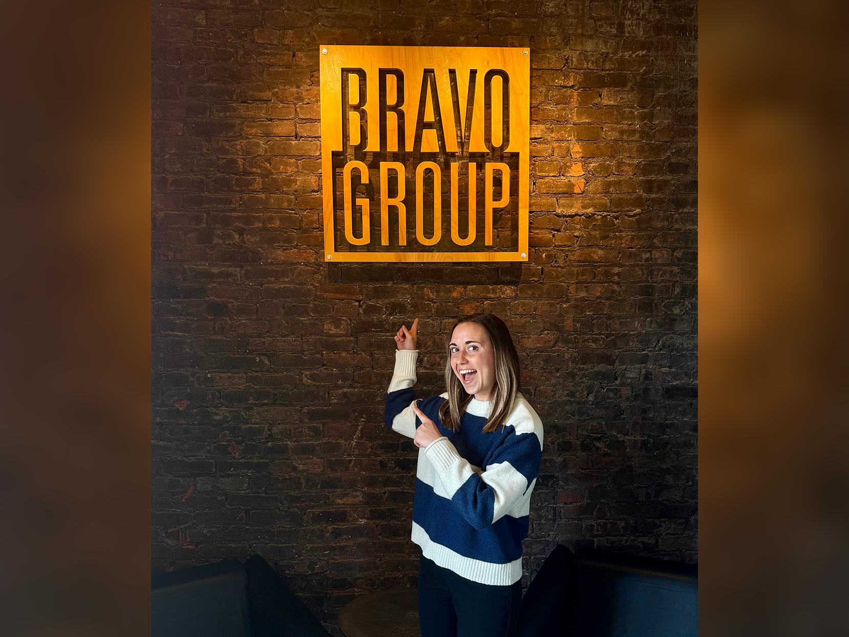 Jessica Barb poses with a Bravo Group sign