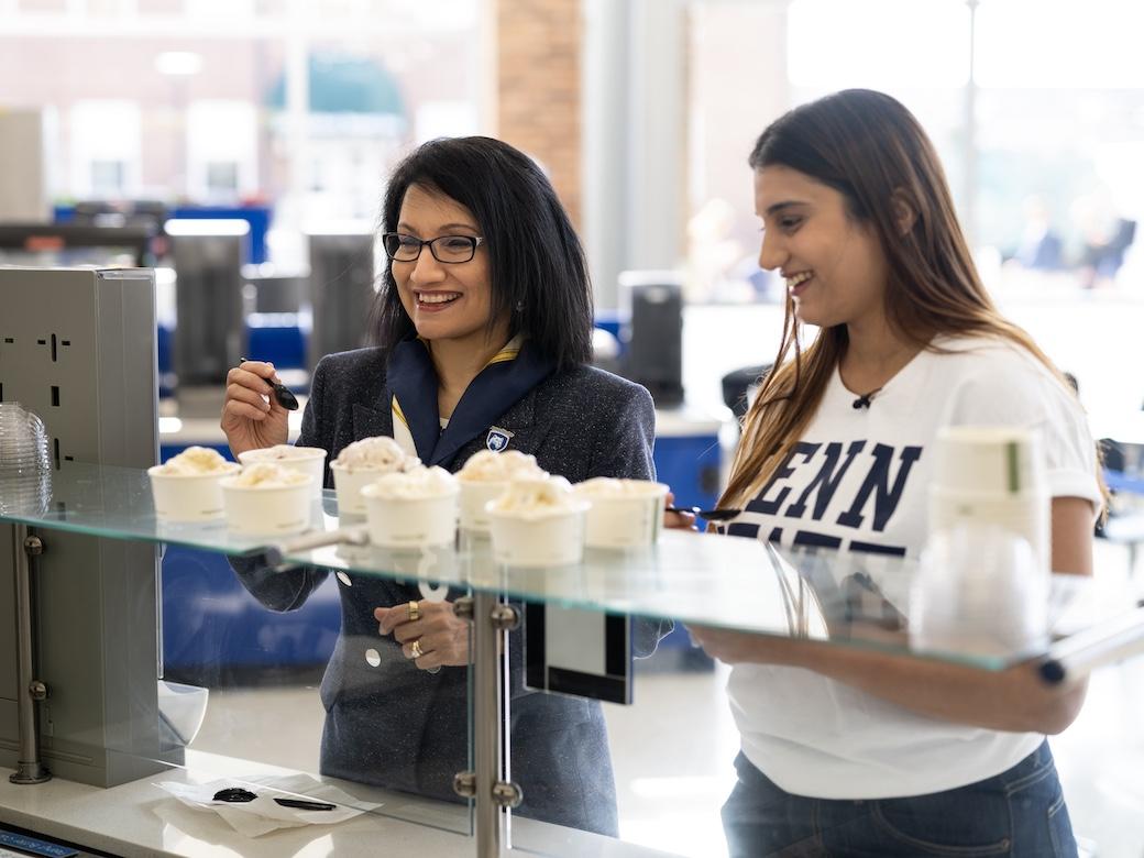 Neeli Bendapudi (left) and student Kavishi Halwavala taste test ice cream flavors at the counter at Berkey Creamery.