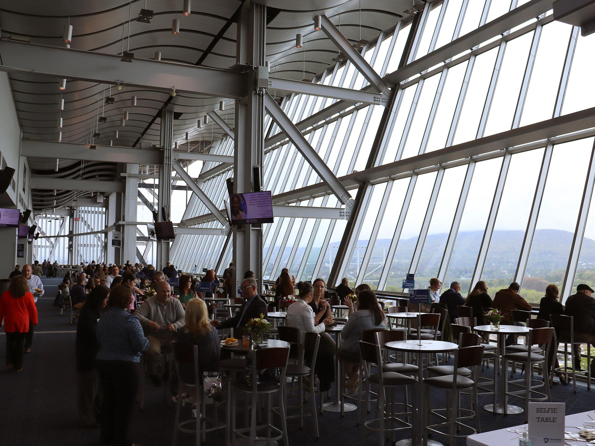 A lounge area with a wall of windows overlooking a mountain.