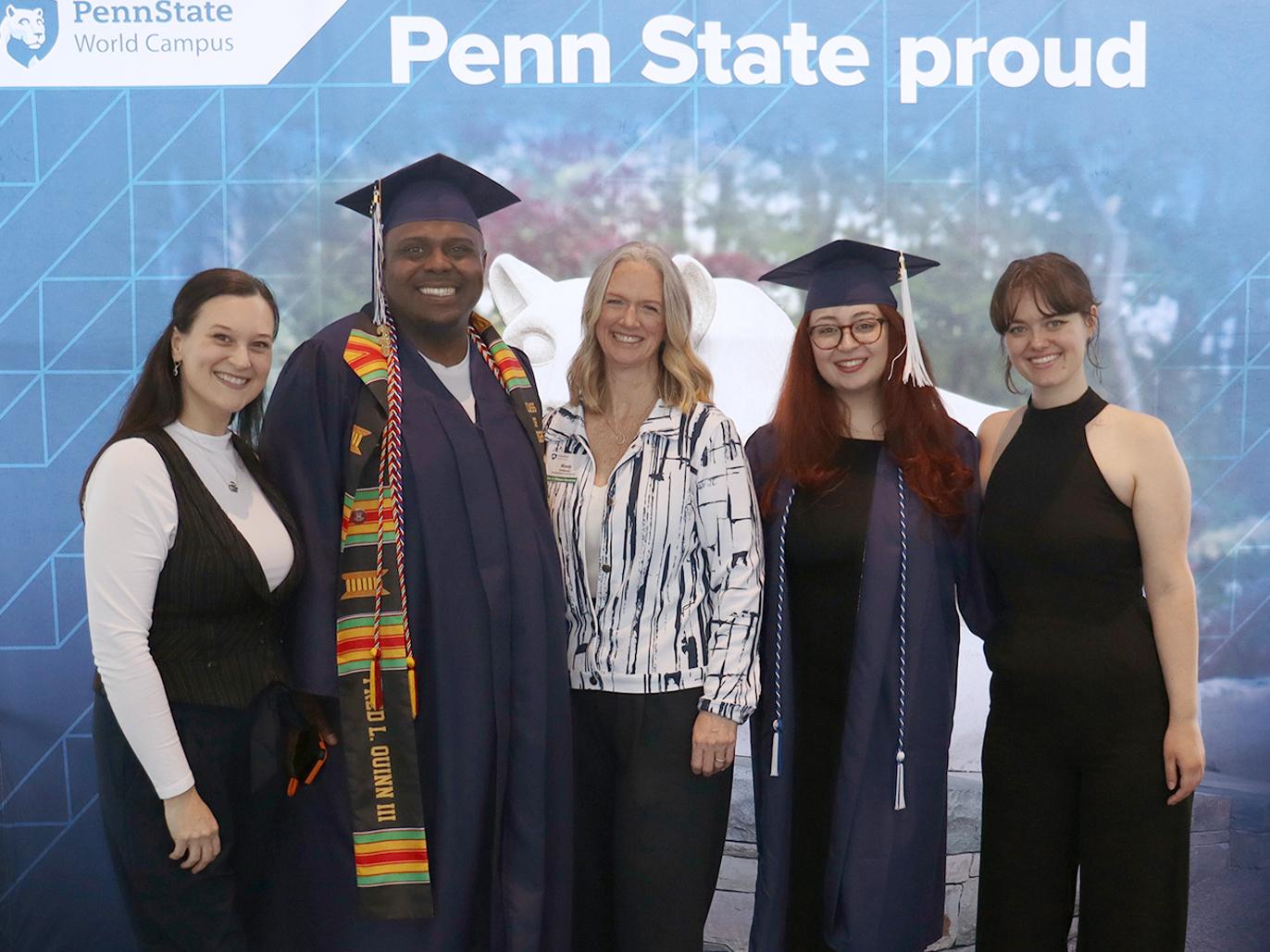 Five people pose in front of a Penn State photo background.