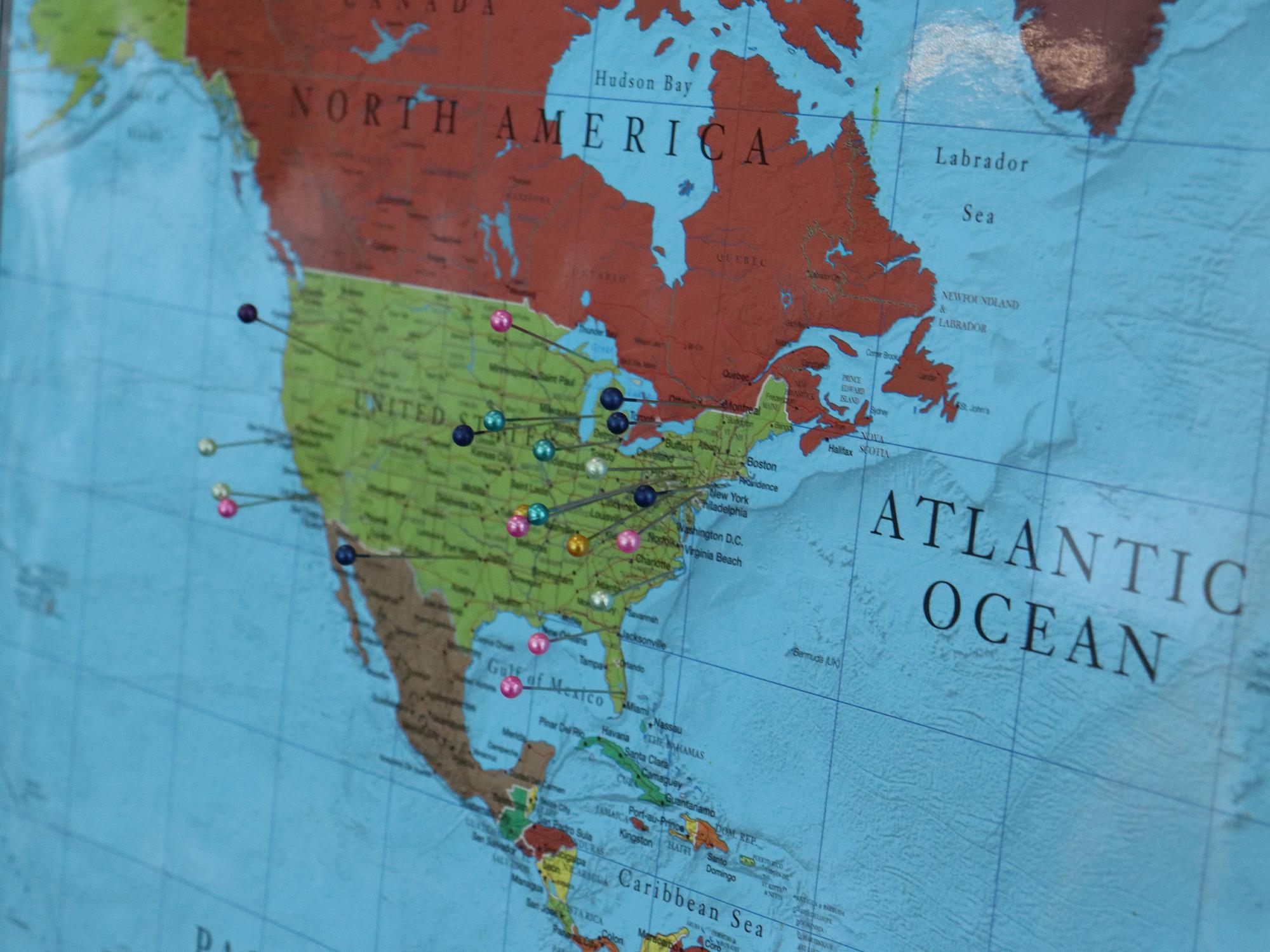 A world map with pins sticking in it.