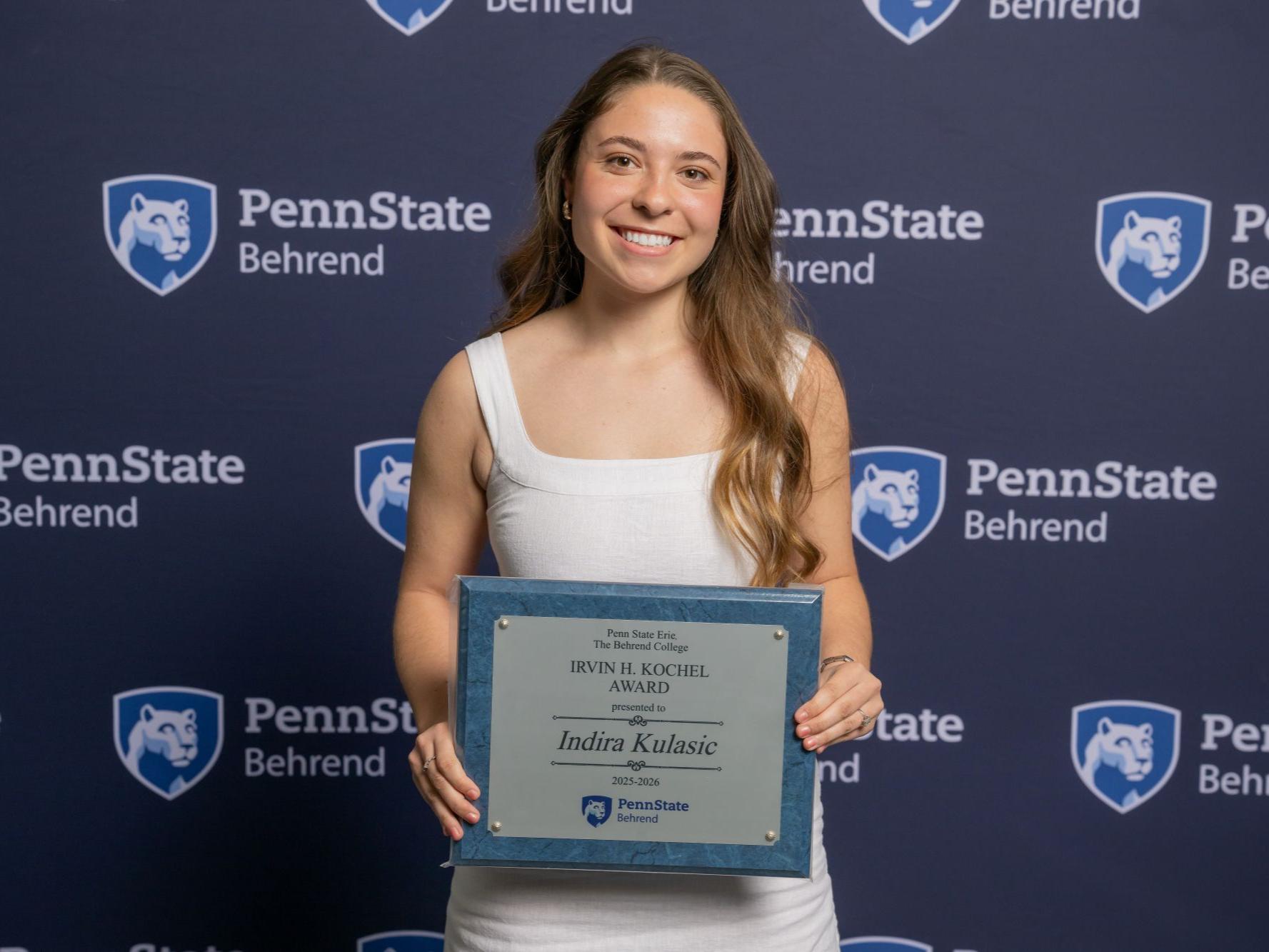 A Penn State Behrend student holds an awards plaque at the college's Honors and Awards Convocation.