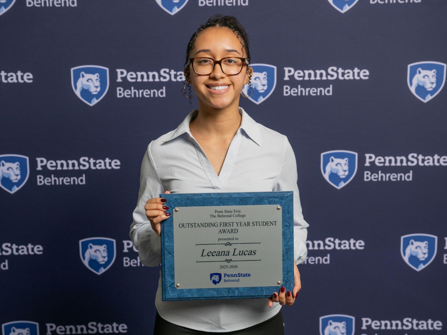 A Penn State Behrend student holds an awards plaque at the college's Honors and Awards Convocation.