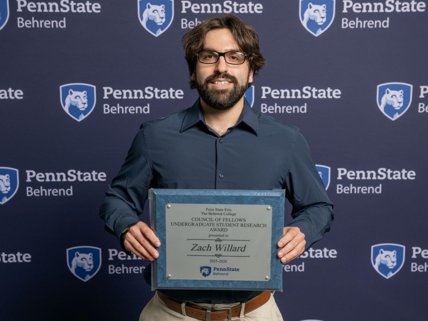 A Penn State Behrend student holds an awards plaque at the college's Honors and Awards Convocation.