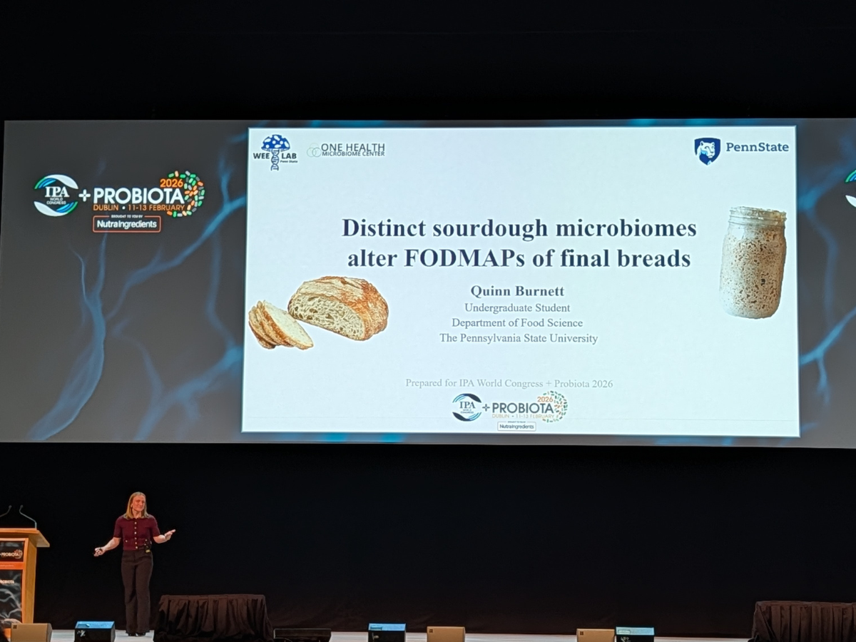 Burnett presenting at the conference under her abstract on a large screen.