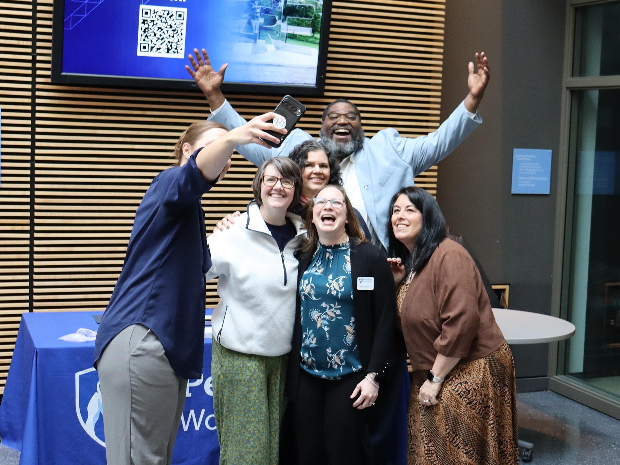 A group of people take a selfie in a lobby.