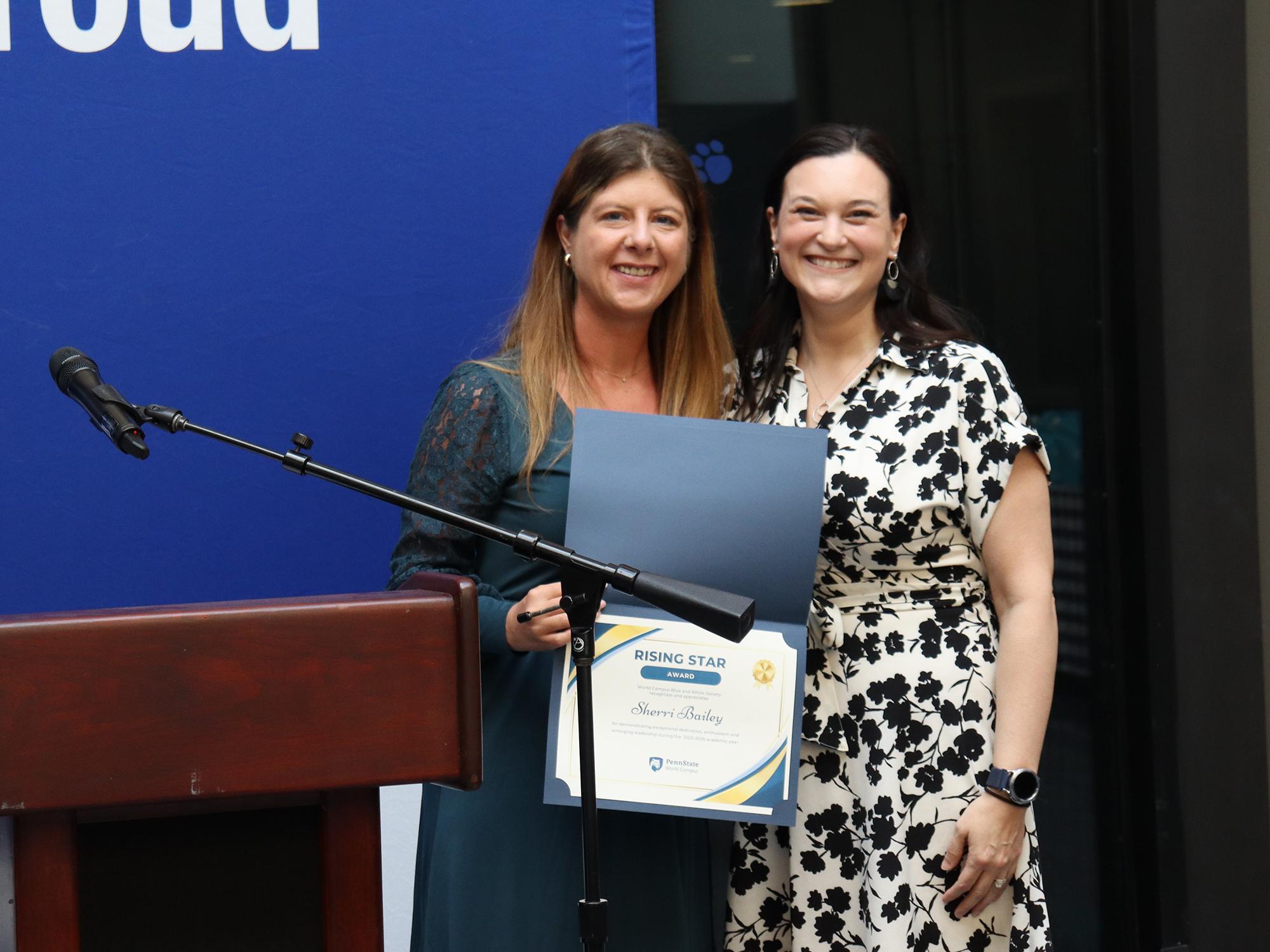 Two woman stand behind a podium.