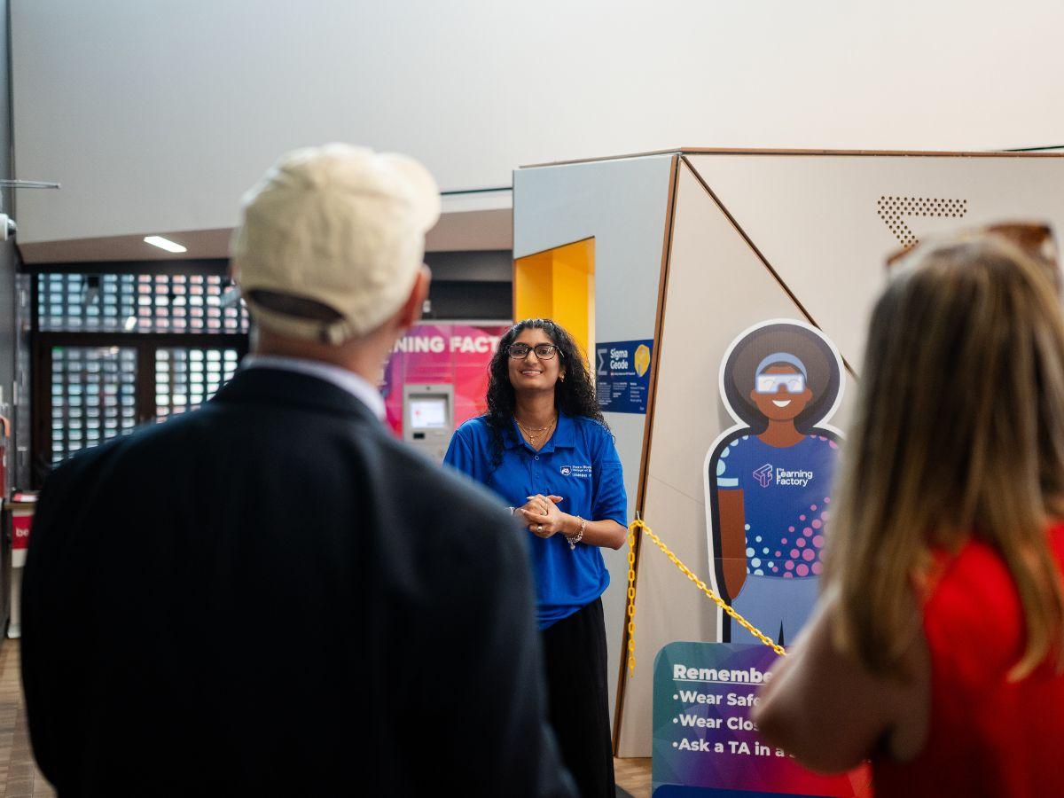 A presenter speaks to a group of visitors during a tour of the Learning Factory.