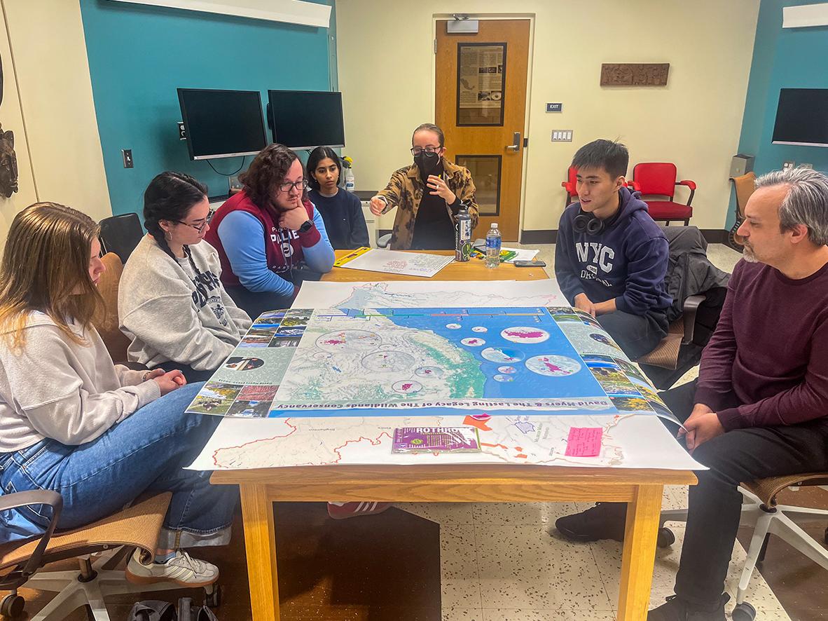 GeoGraphics Lab members review a large-format memorial map during a project feedback meeting.