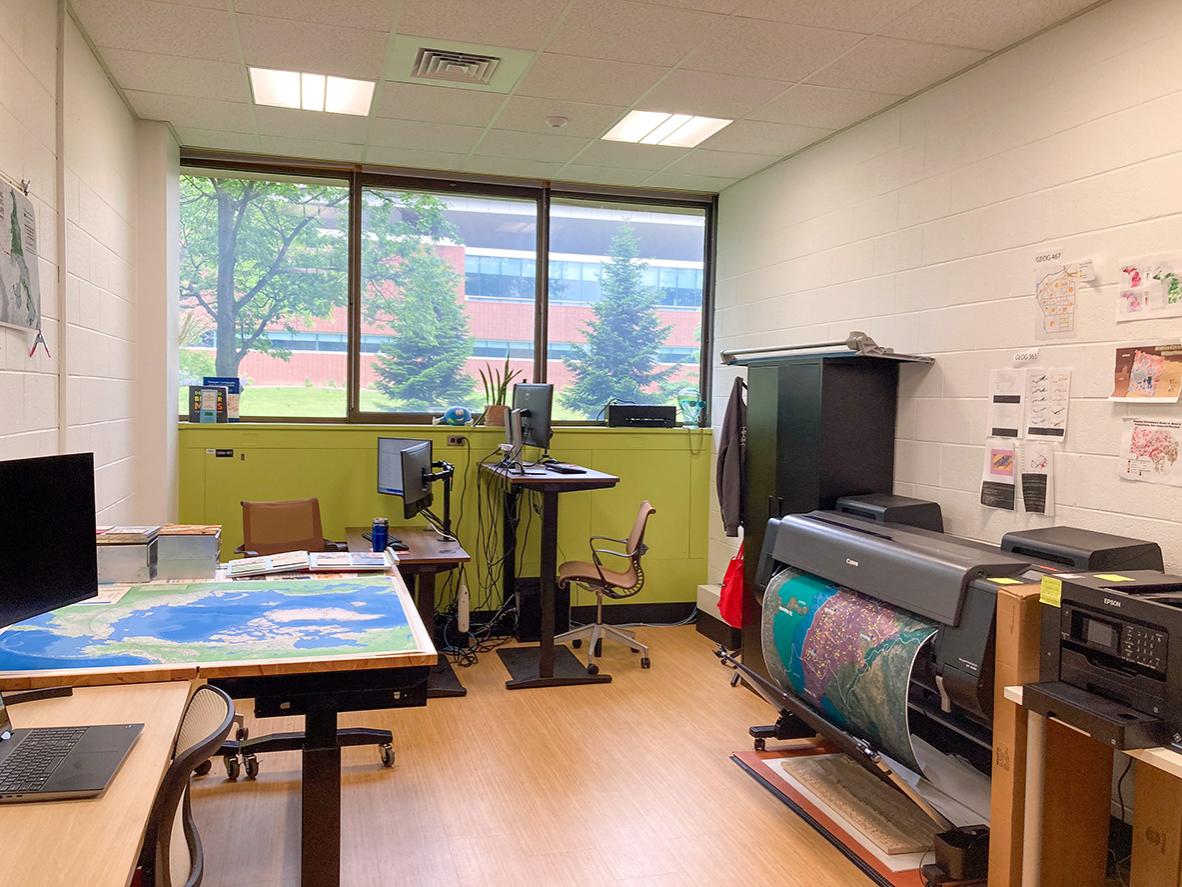 Large-format printers, maps and workstations inside Penn State’s GeoGraphics Lab.