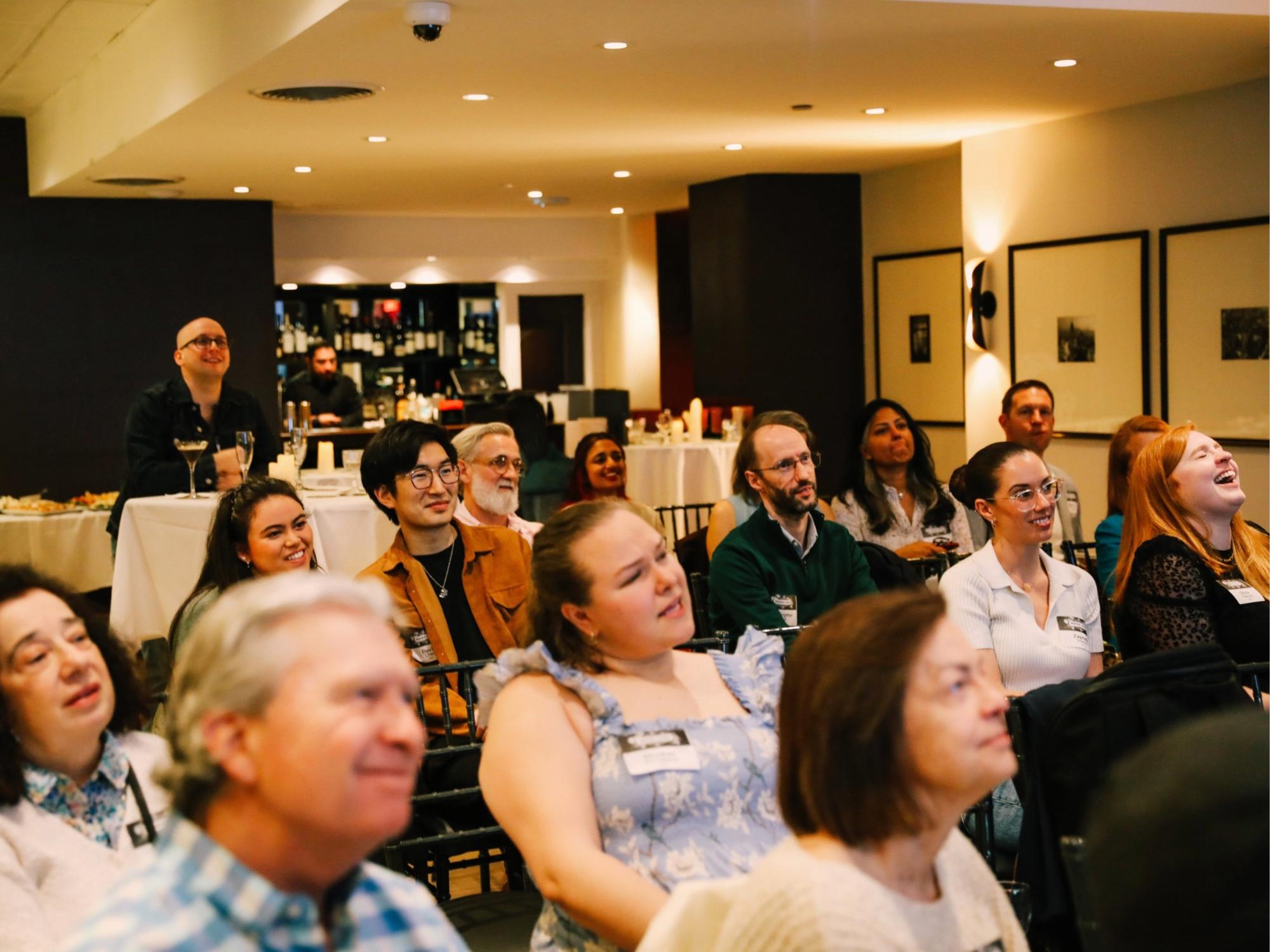 Rows of Penn State alumni actively listen to a lecture