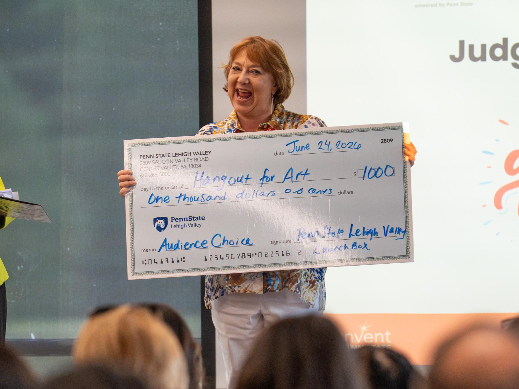 woman smiling holding large check