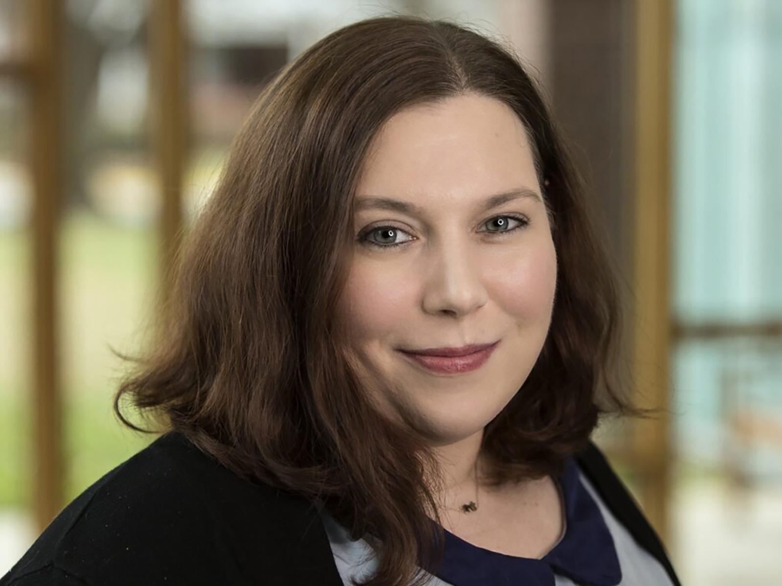 A headshot of a woman with brown hair.