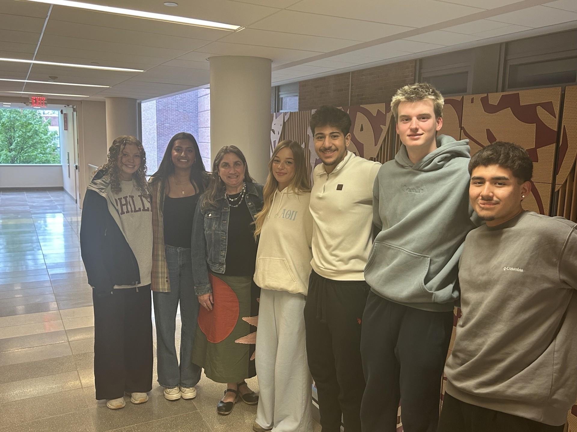 Students gather with Jennifer Murray Connell in a hallway 