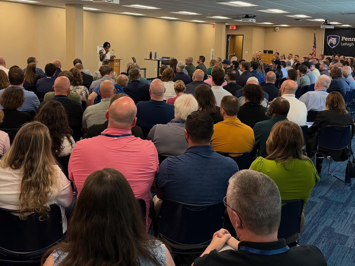 audience facing a woman speaking