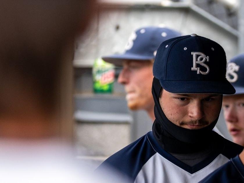 Baseball player bundled up for the game.