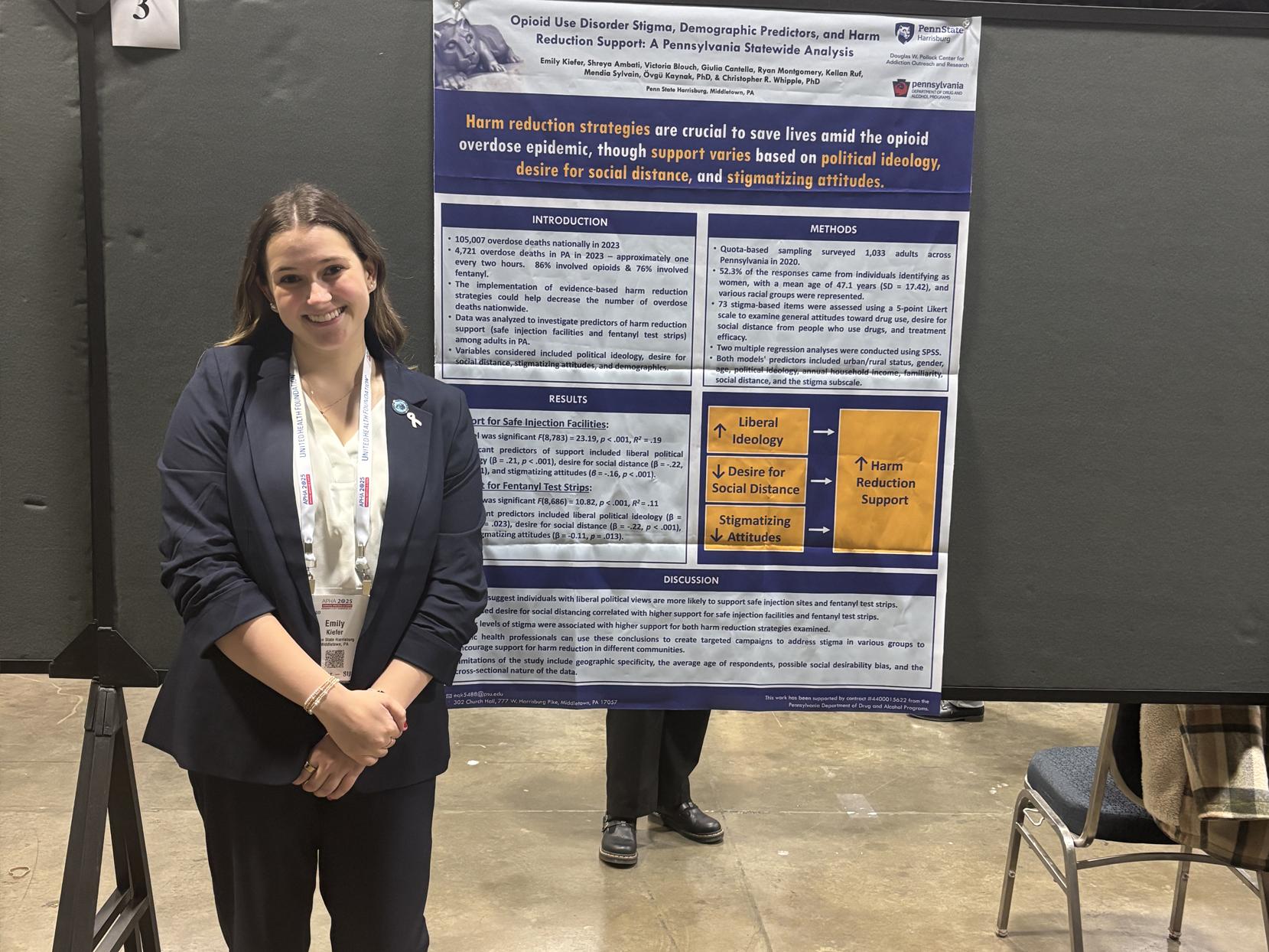 Emily Kiefer stands next to her research poster at a conference