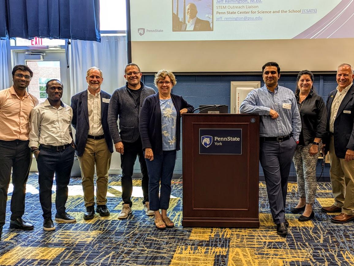 A group of people stand near a podium.